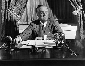 Roosevelt at desk in front of microphones
