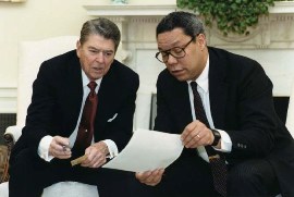 Colin Powell and President Ronald Reagan looking at document